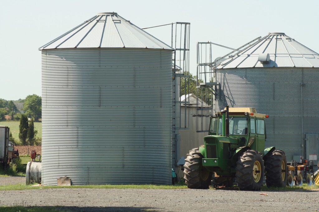 Grain bins and a green tractor on a farmstead